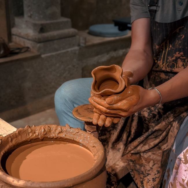 A maker shaping clay at the wheel